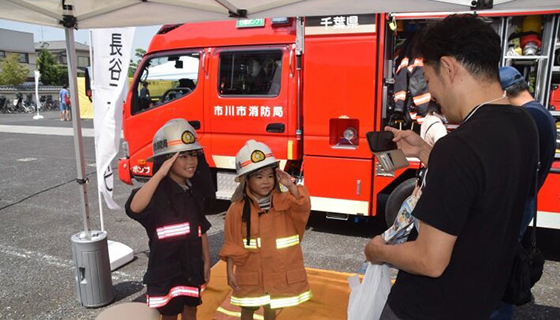 Children posing for a commemorative photo in firefighter gear