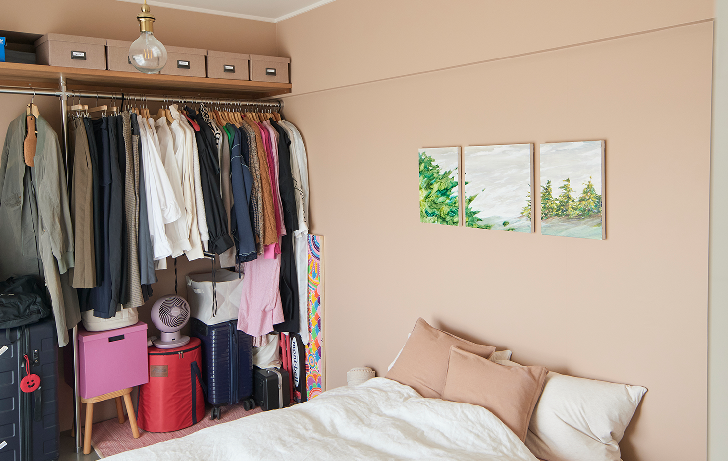 寝室はアクセントにグレイッシュなピンクの壁紙を使用。ベッドの上には画家の植田陽貴さんに描いてもらった風景画が飾られている