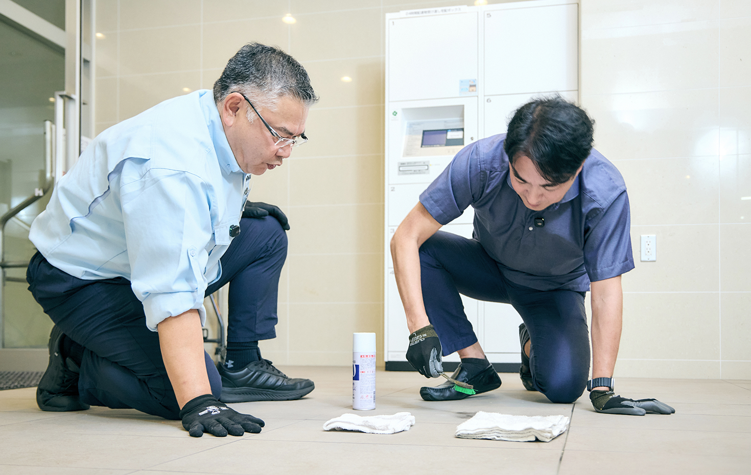 マンションのエントランスを再現した研修施設で、清掃の講習を受けた西岡さん。講師からは「できるかぎり水拭きで清掃し、洗剤を使用する場合も、安全性が確認された規定のものに限定している」とレクチャーを受けた
