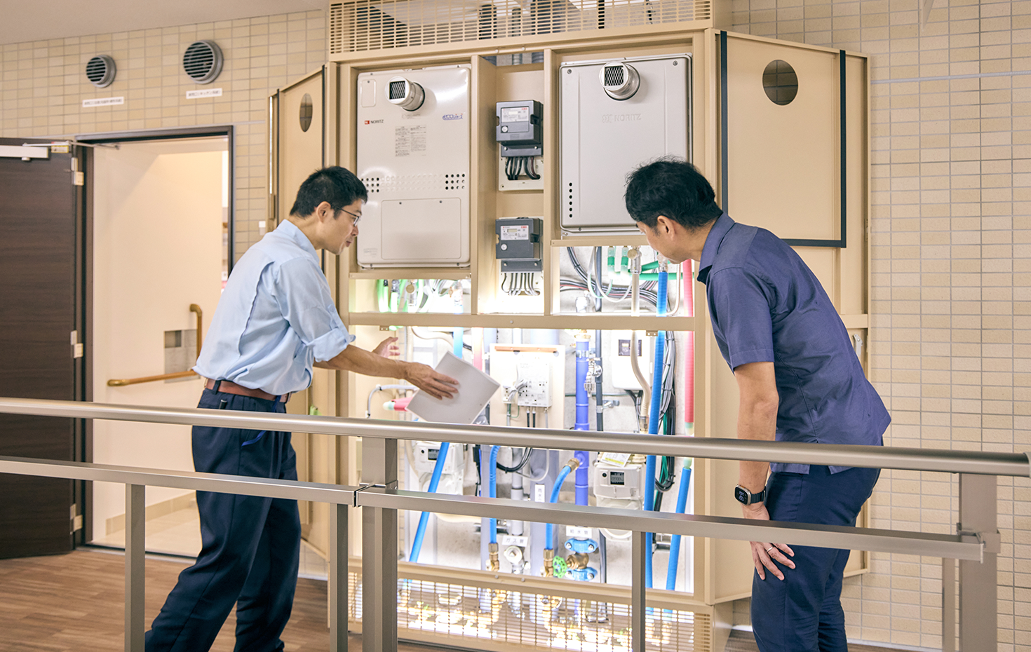 設備の内部の仕組みについて、説明を受ける西岡さん