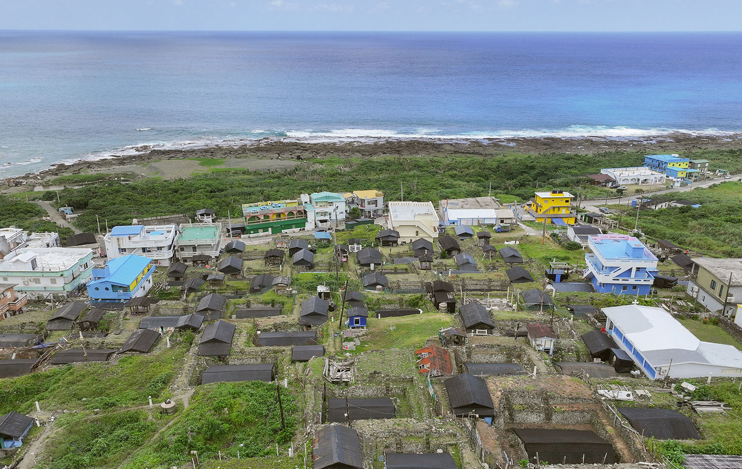 地面に沈み込むように並ぶ地下屋の周囲には、現代的な住宅も建つ