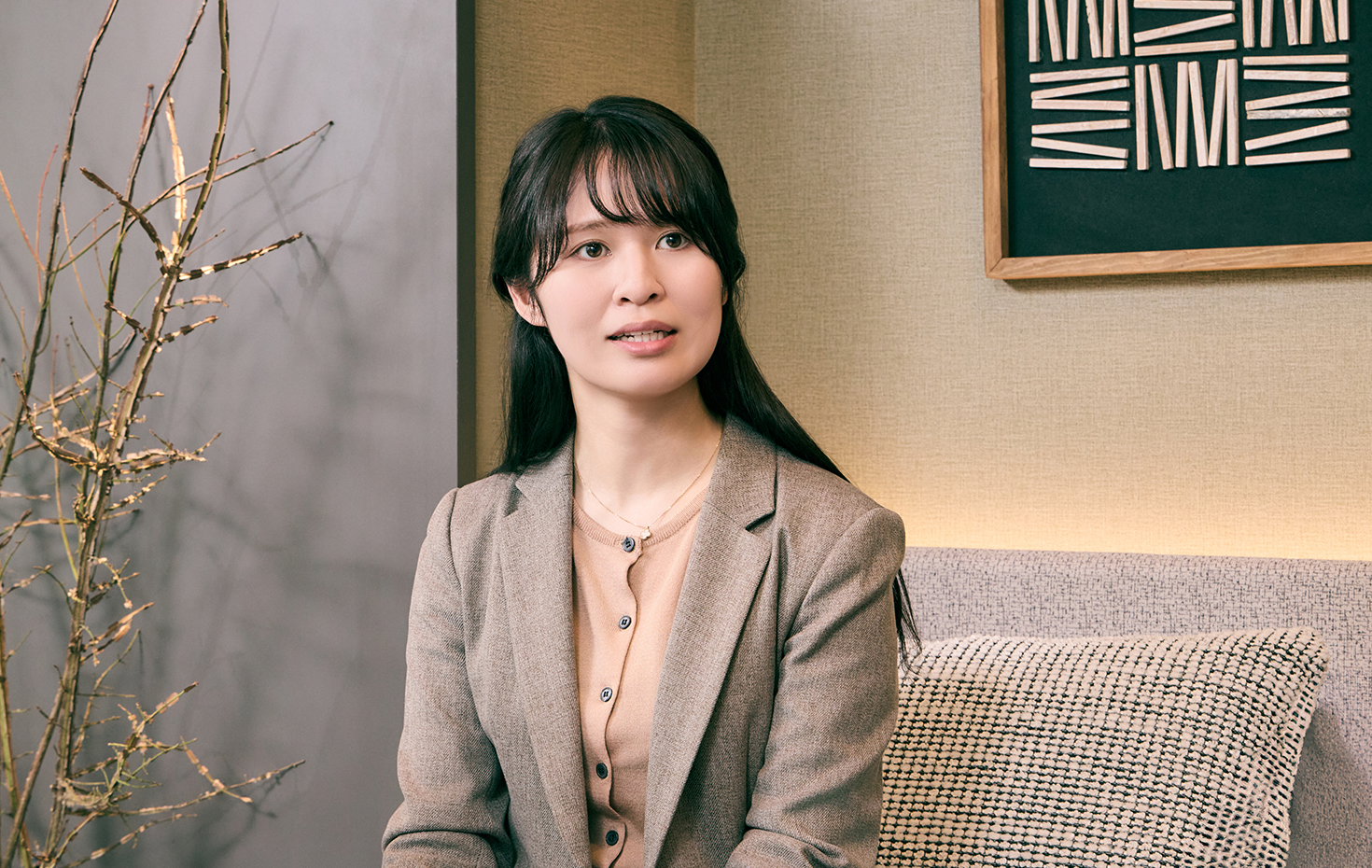 低層マンションと、ルネグラン上石神井の魅力を語る担当者の写真