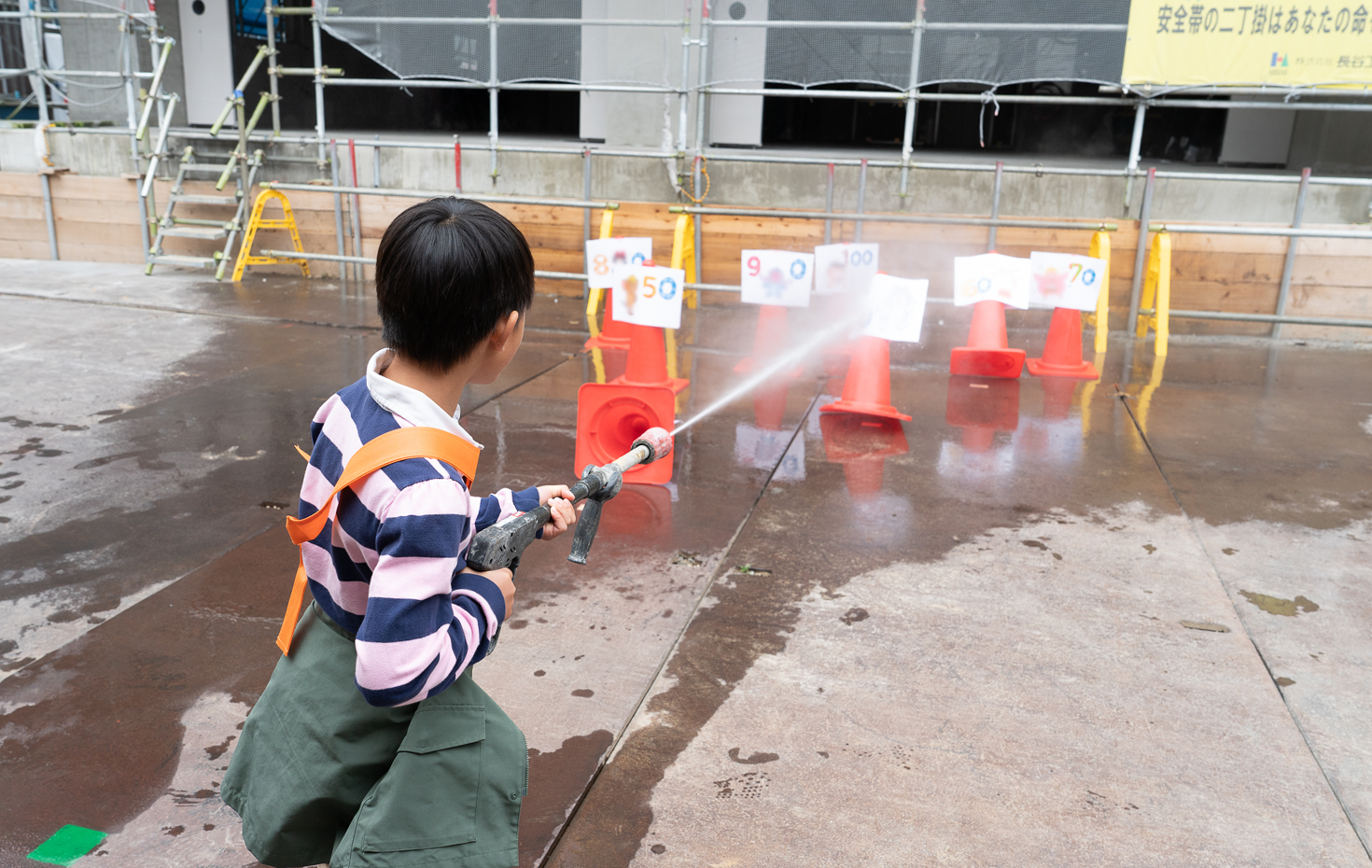高圧洗浄機の強い水流で的当てに挑戦。毎年人気の定番プログラムだ