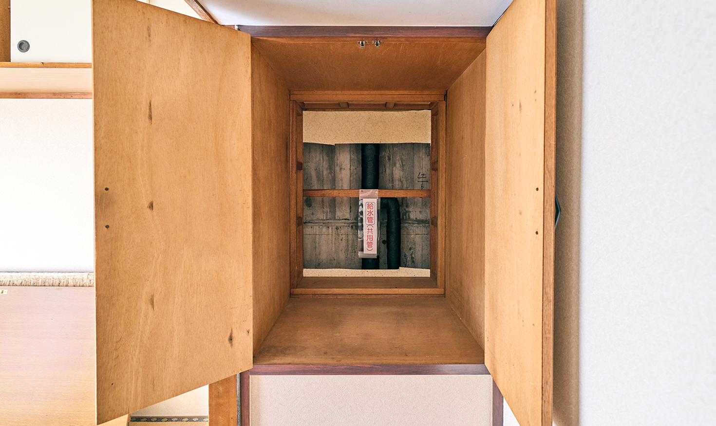 府中日鋼団地の室内。給水管が押入れの裏を通り、修繕工事が難しい状況だった