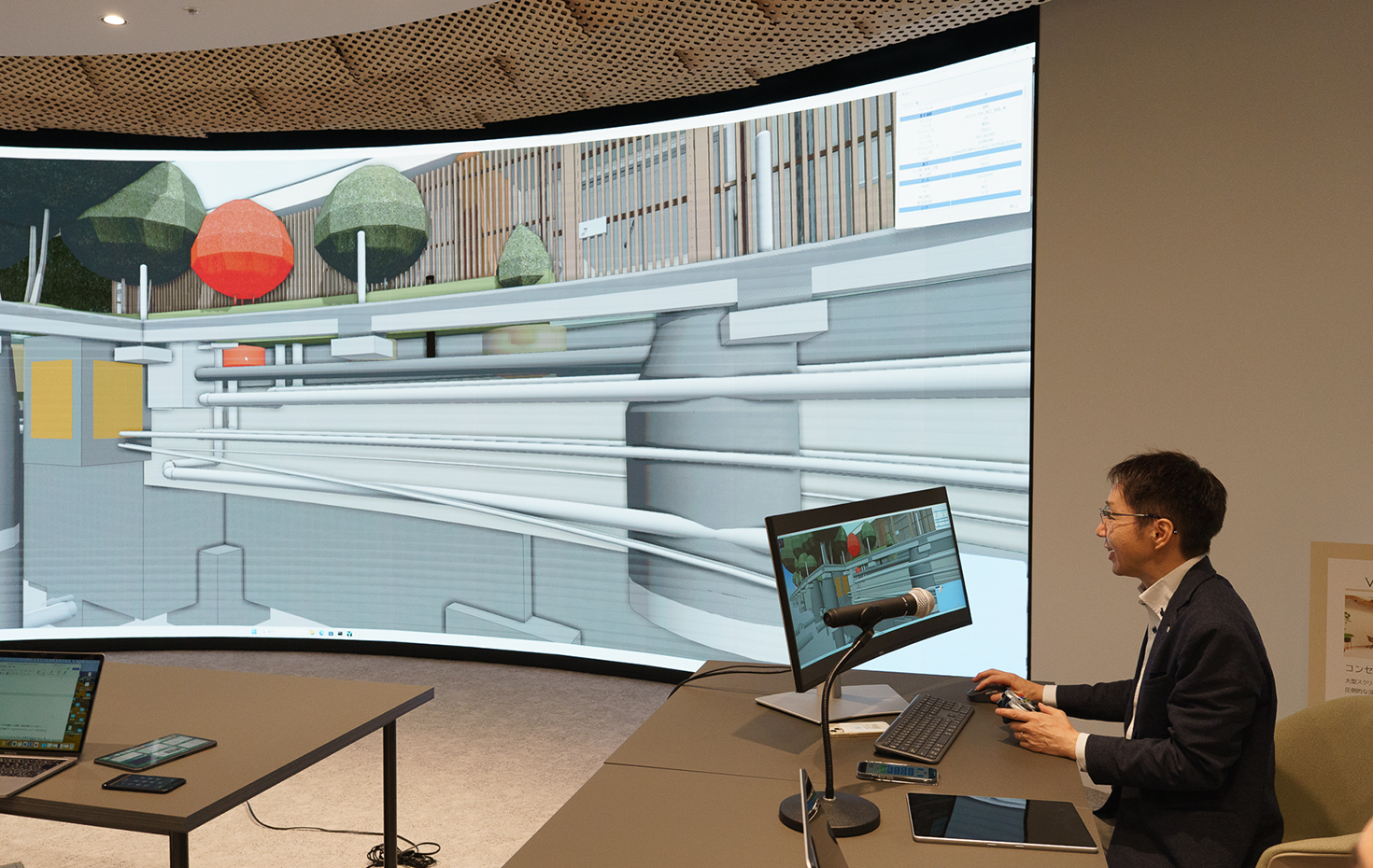 大画面でのプレゼンテーション風景。複数の関係者が同時に映像を共有し、リアルタイムで注釈を入れながら議論できるため、より効果的な合意形成が可能